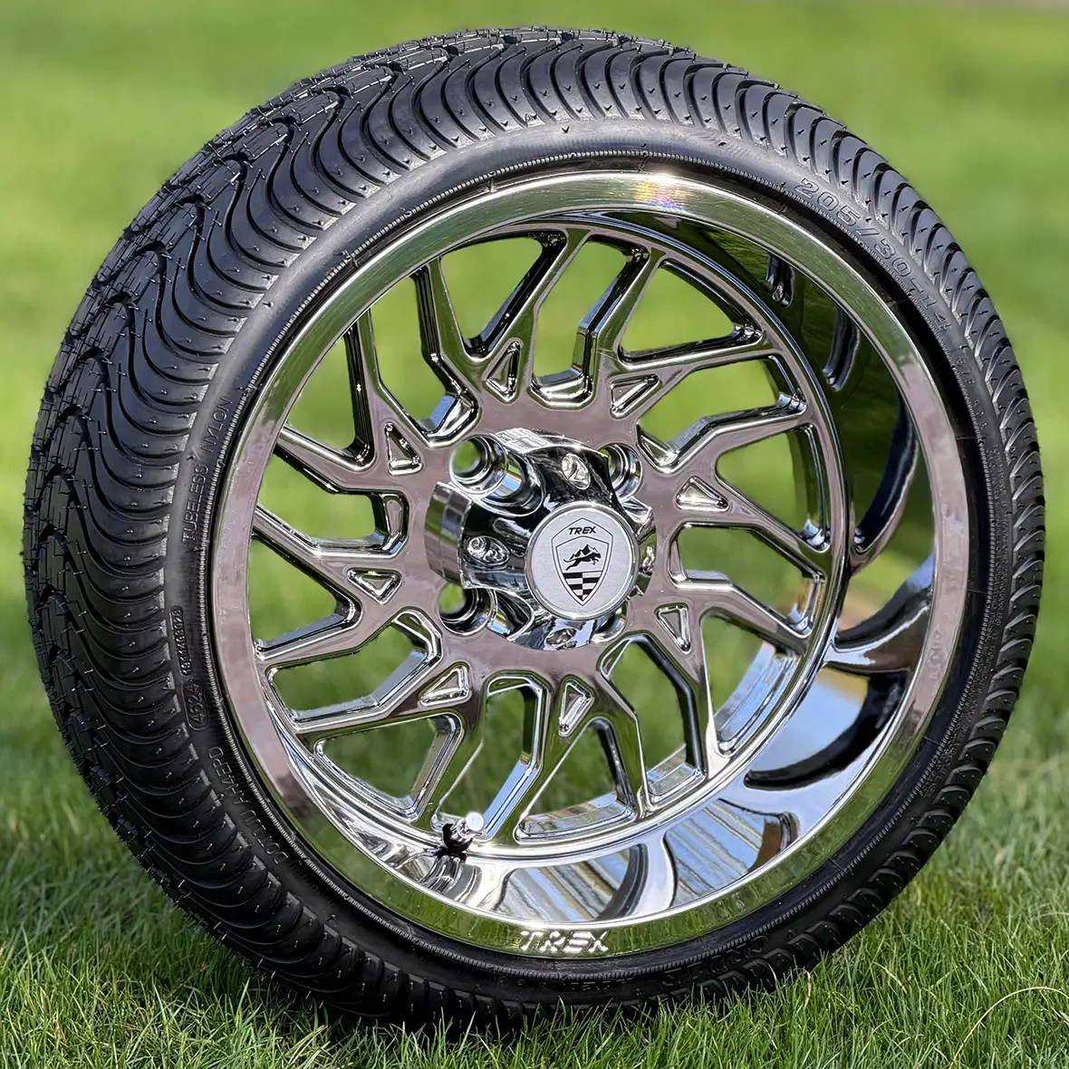 TREX 14 inch BLITZ Chrome Golf Cart Wheels and 205/30-14 Golf Cart Tires standing in Grass