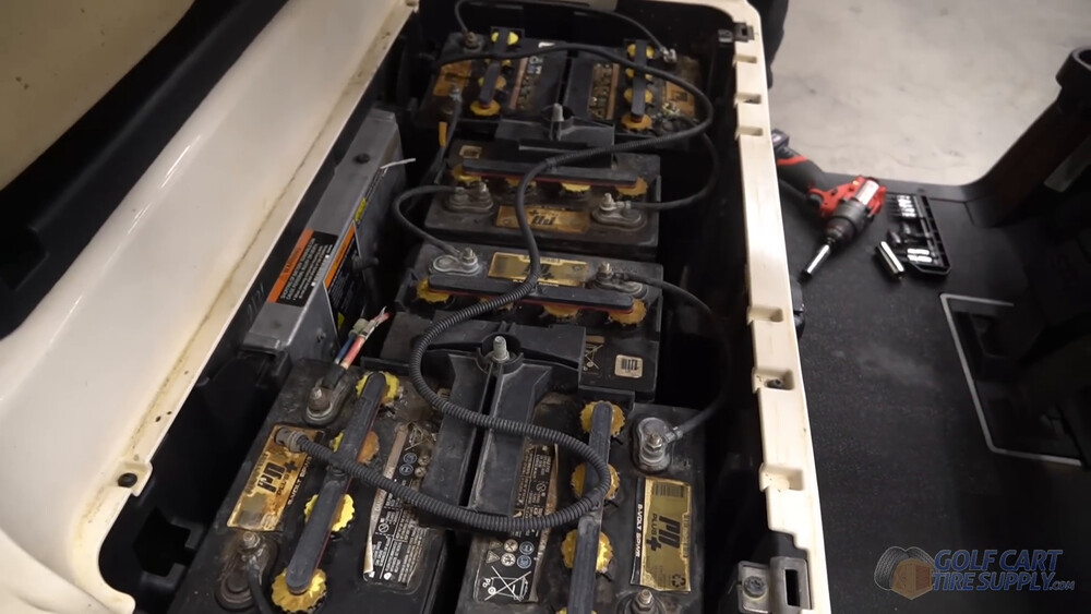 Club Car Tempo lead-acid battery bay Six lead-acid batteries and their cables in the battery bay of a white 2019 Club Car Tempo golf cart