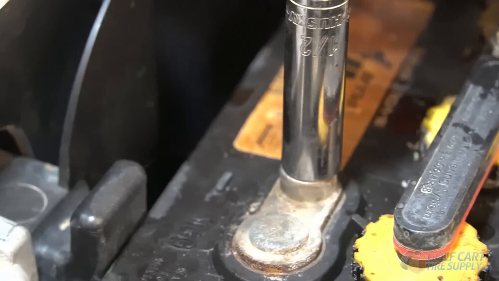 Disconnecting Club Car Tempo battery cables Half inch socket on a lead-acid battery terminal while disconnecting the cables in a 2019 Club Car Tempo golf cart