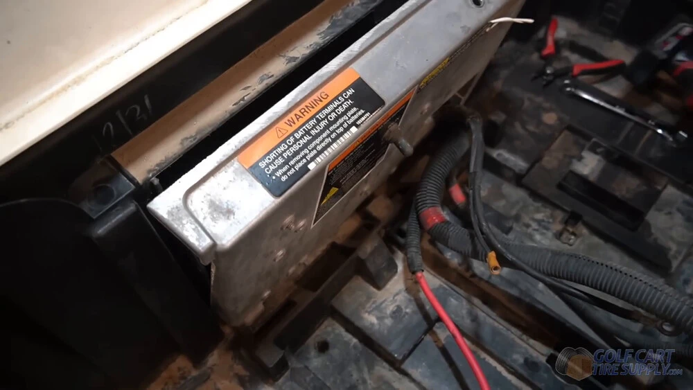 Club Car Tempo silver panel and motor controller Silver panel lowered to reach the motor controller wiring in the battery bay of a white 2019 Club Car Tempo golf cart