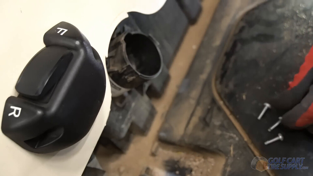 Club Car Tempo charge receptacle removed Empty charge port opening and the three saved receptacle screws on a white 2019 Club Car Tempo golf cart