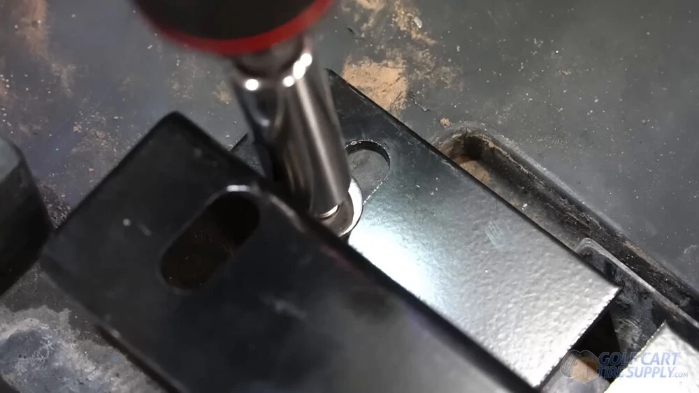 Bolting a battery bracket into a Club Car Tempo Socket tightening a bolt and large washer through a lithium battery bracket in a 2019 Club Car Tempo golf cart