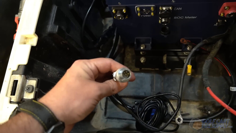 SOC meter cable at the ALLIED battery in a Club Car Tempo Silver SOC meter cable connector held up to the ALLIED lithium battery ports in a 2019 Club Car Tempo golf cart