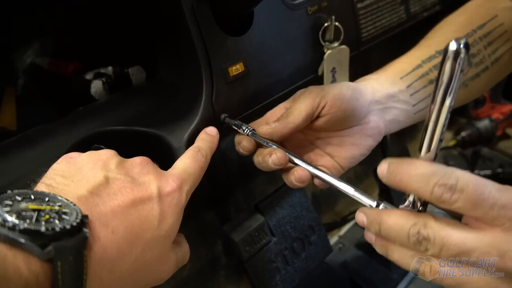 Removing the Club Car Tempo center dash panel Removing a T27 screw from the center dash panel of a 2019 Club Car Tempo golf cart