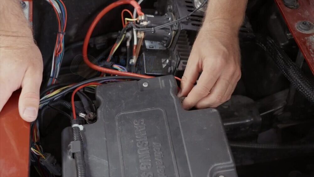 Disconnecting the factory battery terminal cables on an EZGO RXV Loosening and grouping the factory battery terminal cables on a Gen 1 EZGO RXV